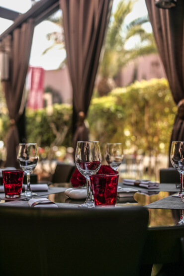 Terrasse spacieuse et élégante du restaurant La Table du Marché à l'Hivernage Hotel & Spa, avec une vue sur l'extérieur et les tables dressées